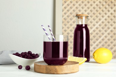 Delicious acai juice, berries and lemon on white wooden table