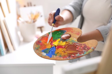 Photo of Woman with knife using palette indoors, closeup