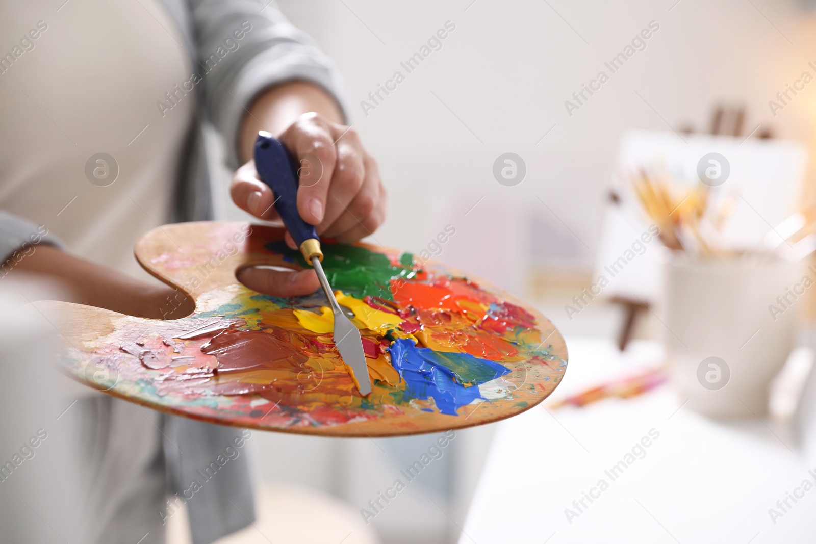 Photo of Woman with knife using palette indoors, closeup