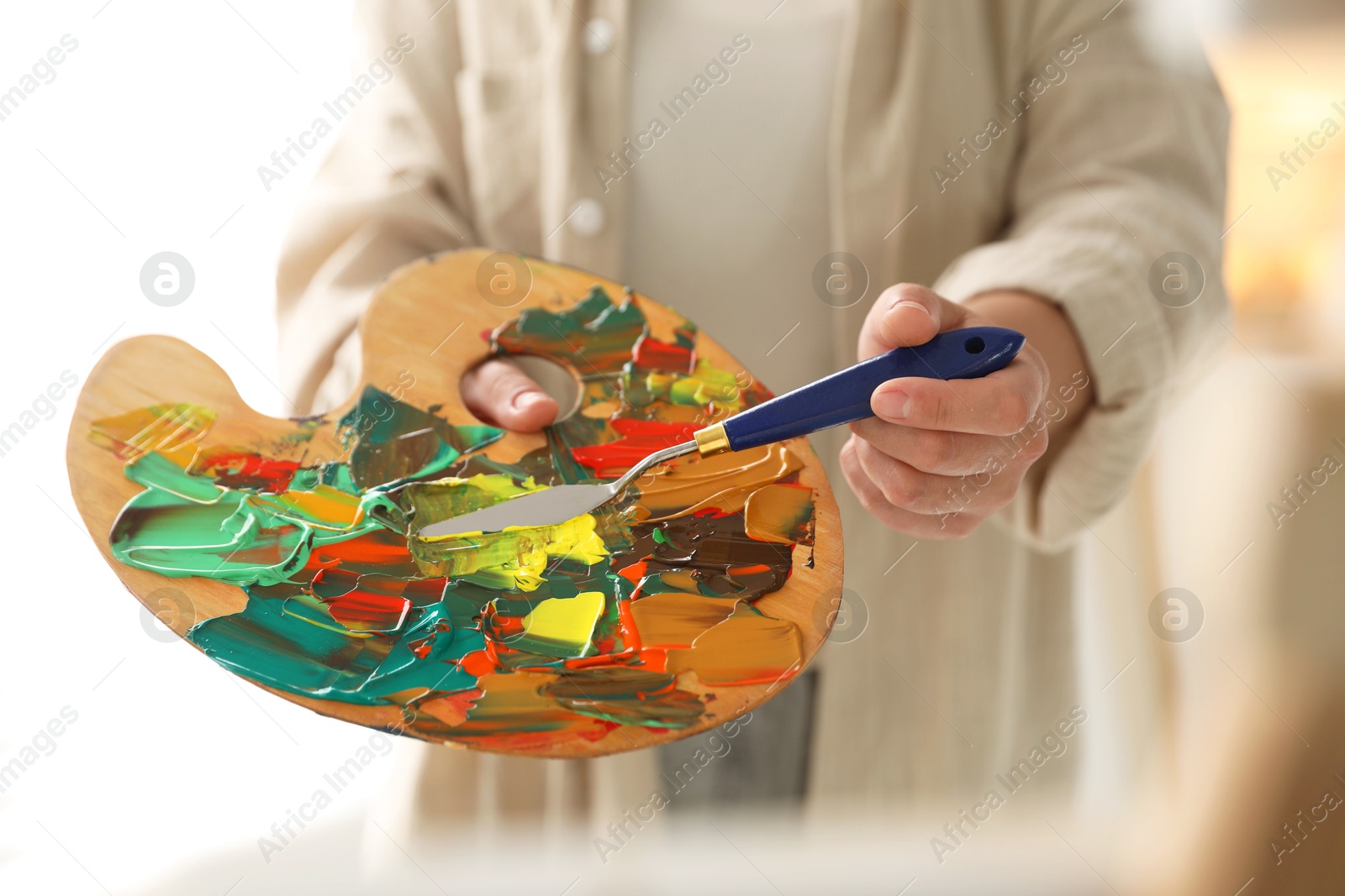 Photo of Woman with knife using palette indoors, closeup