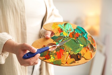 Photo of Woman with knife using palette indoors, closeup