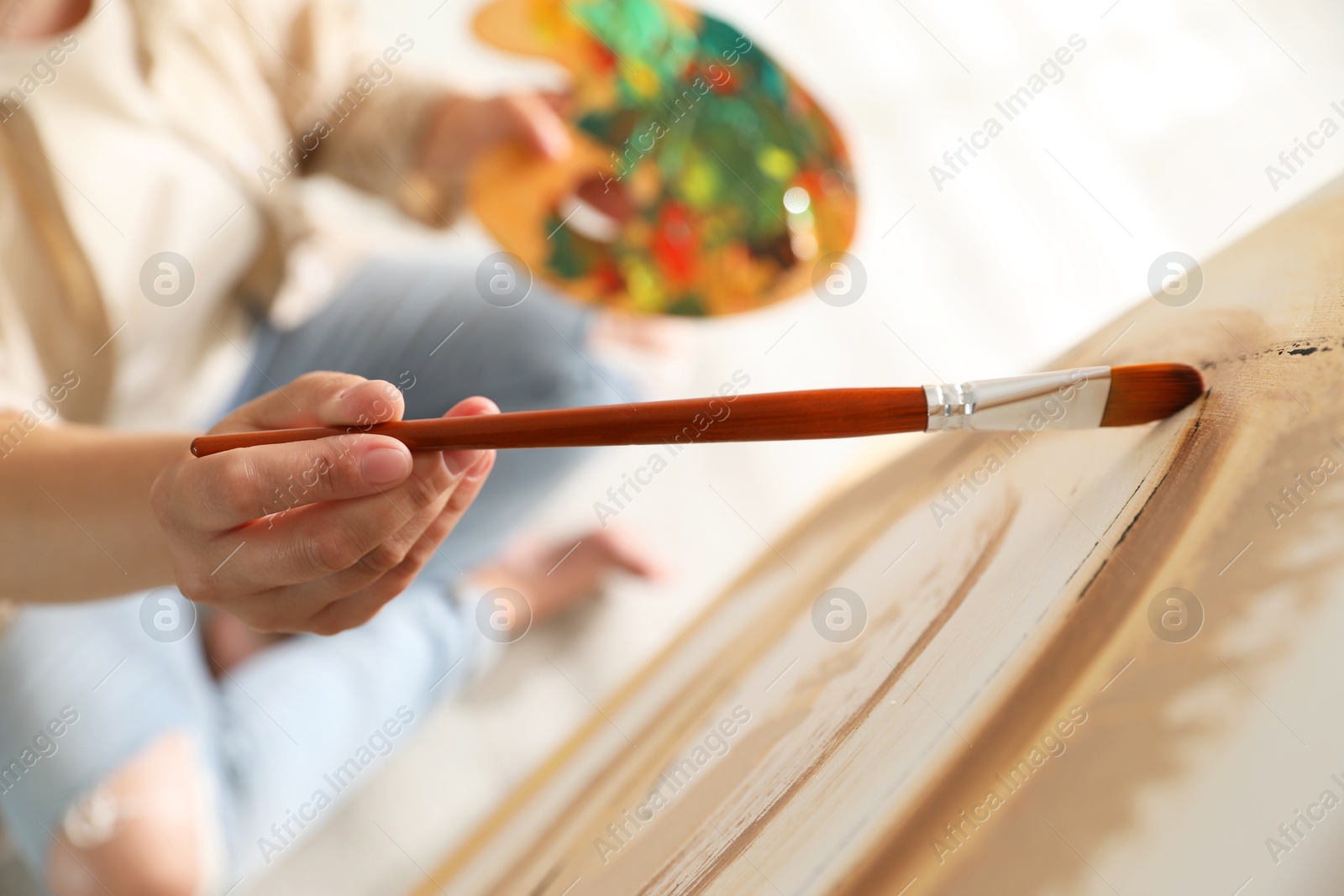 Photo of Woman painting on easel with canvas indoors, closeup