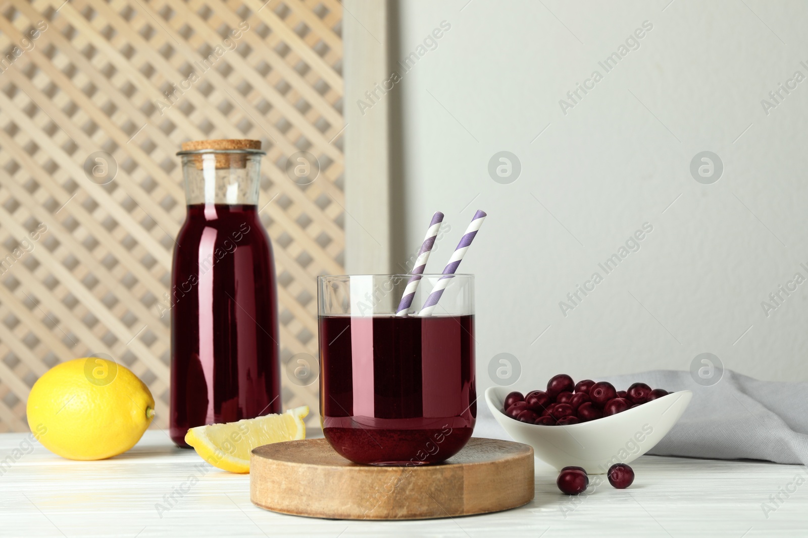 Photo of Delicious acai juice, berries and lemon on white wooden table