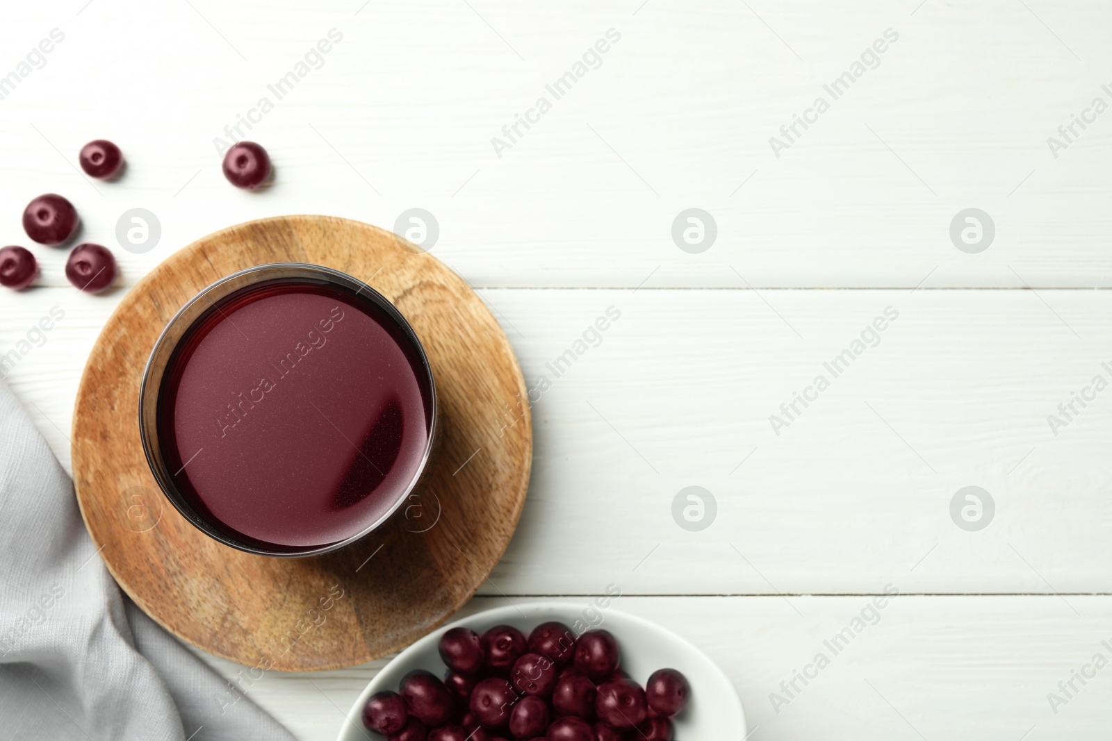 Photo of Delicious acai juice in glass and berries on white wooden table, flat lay. Space for text