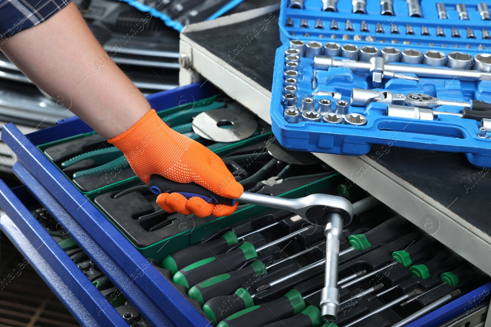 Photo of Auto mechanic with torque wrench and different tools at automobile repair shop, closeup