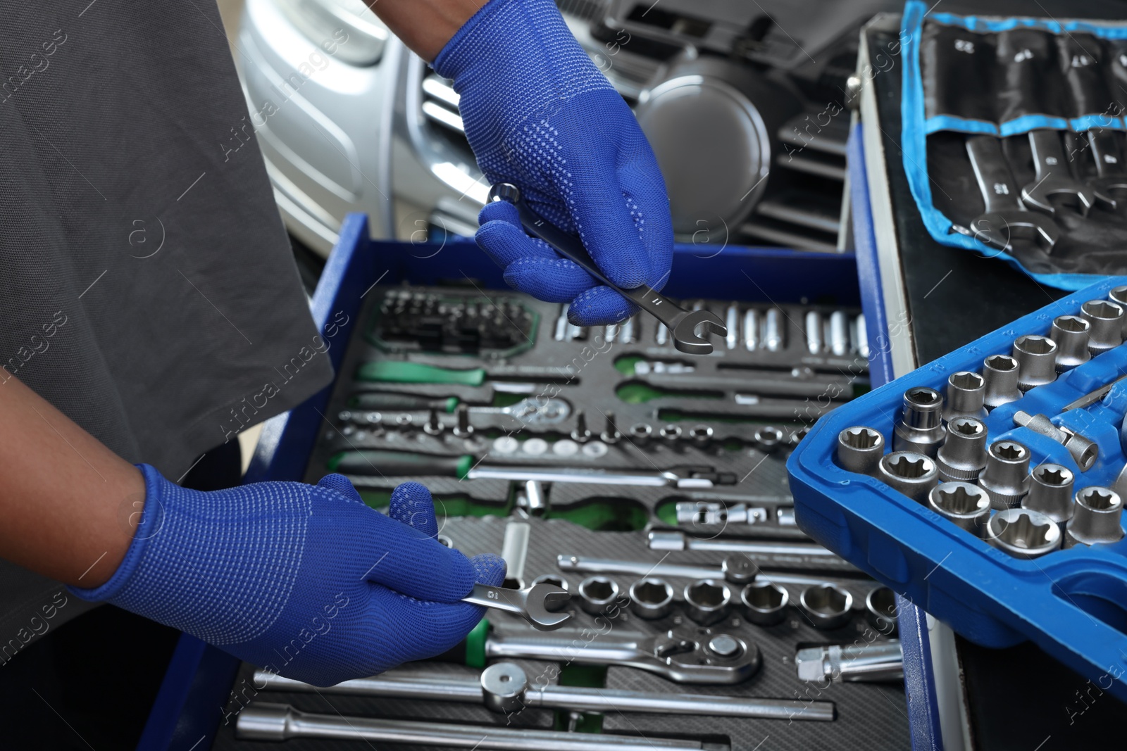 Photo of Auto mechanic with different tools at automobile repair shop, closeup