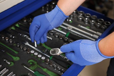 Photo of Auto mechanic with different tools at automobile repair shop, closeup