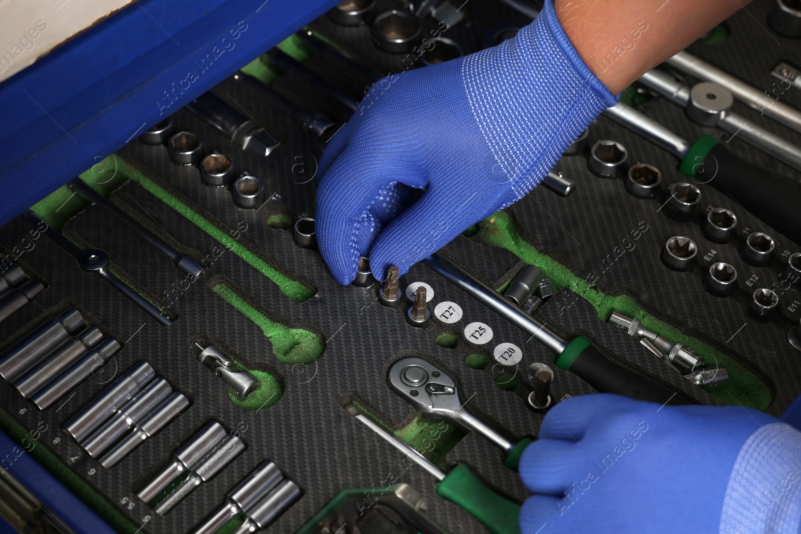 Photo of Auto mechanic with different tools at automobile repair shop, closeup