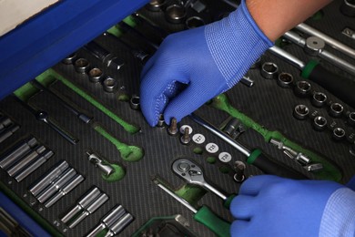 Photo of Auto mechanic with different tools at automobile repair shop, closeup