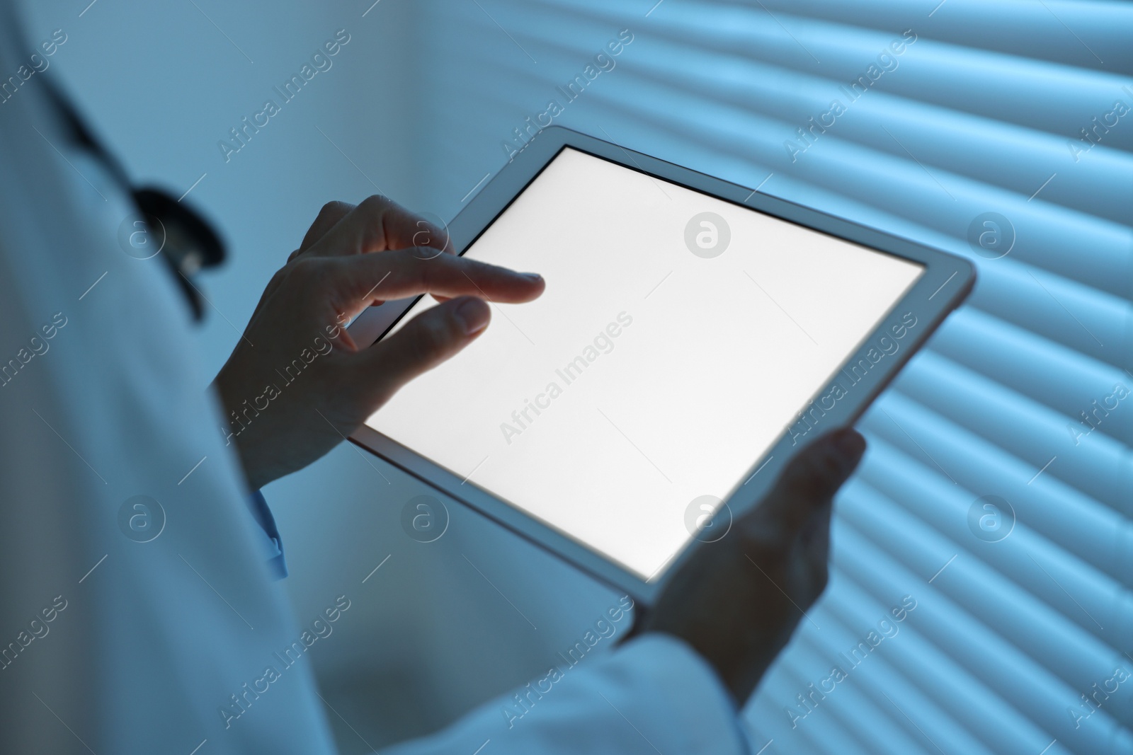 Photo of Doctor using tablet in hospital at night, closeup