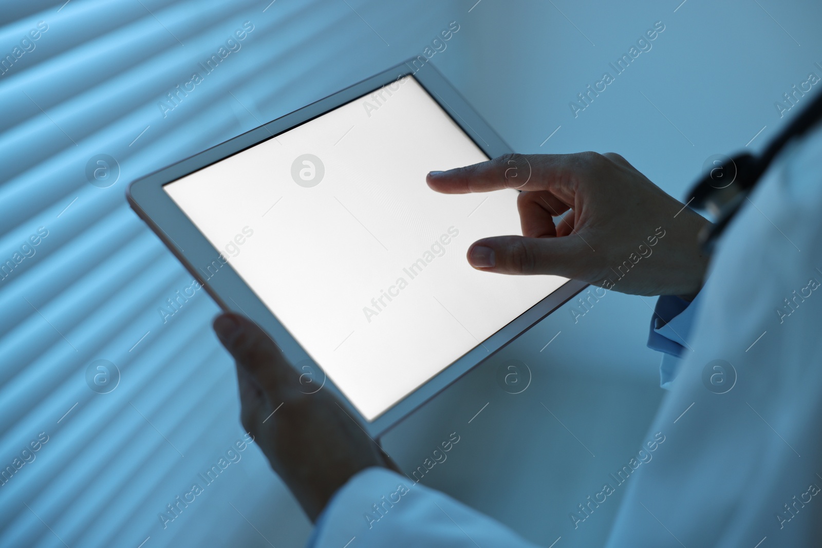 Photo of Doctor using tablet in hospital at night, closeup