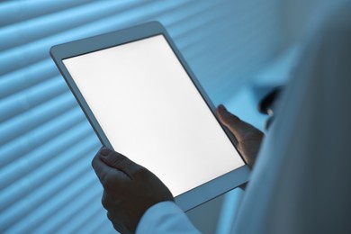 Photo of Doctor using tablet in hospital at night, closeup