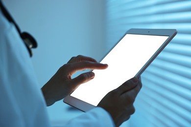 Photo of Doctor using tablet in hospital at night, closeup