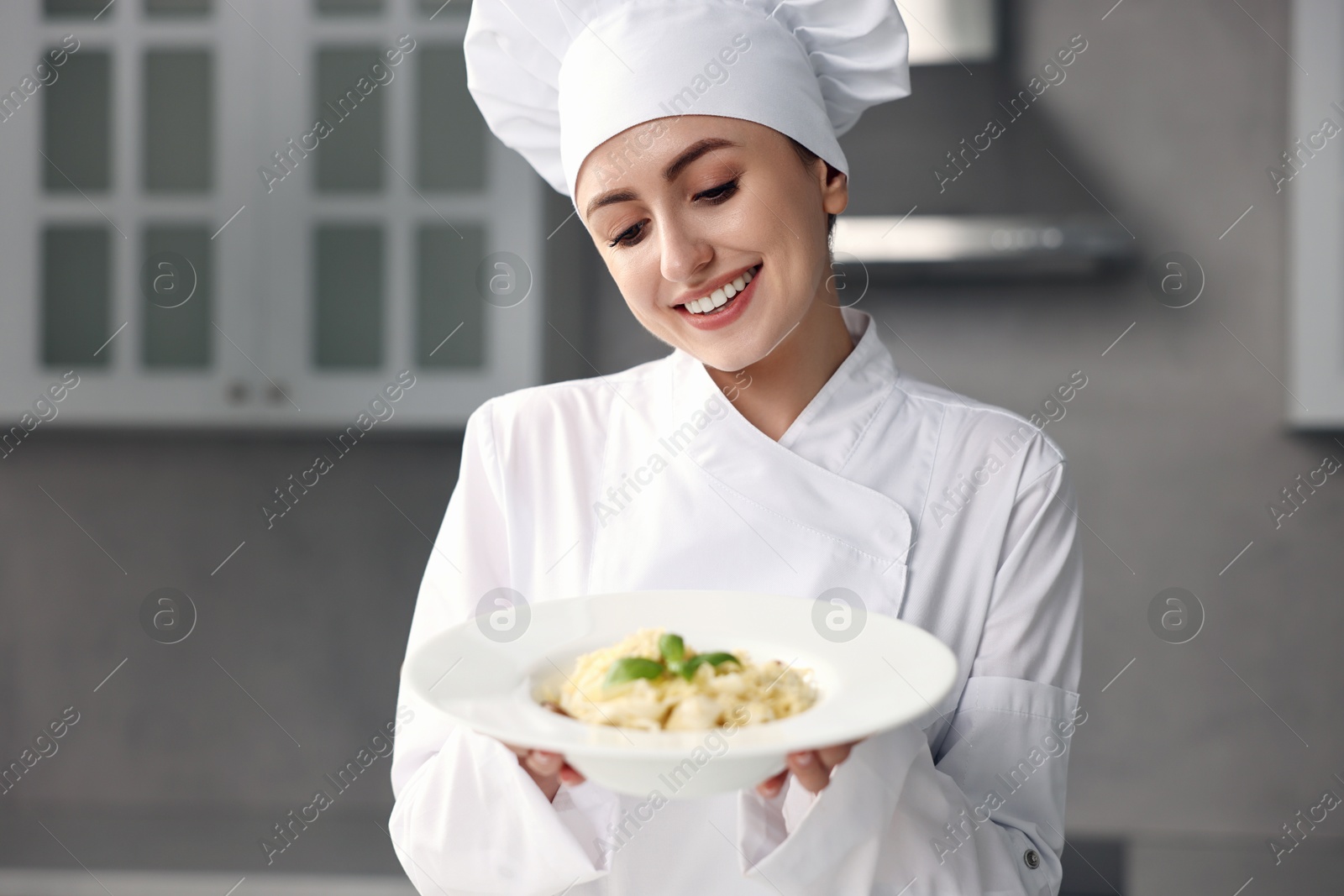 Photo of Professional chef with delicious pasta in kitchen