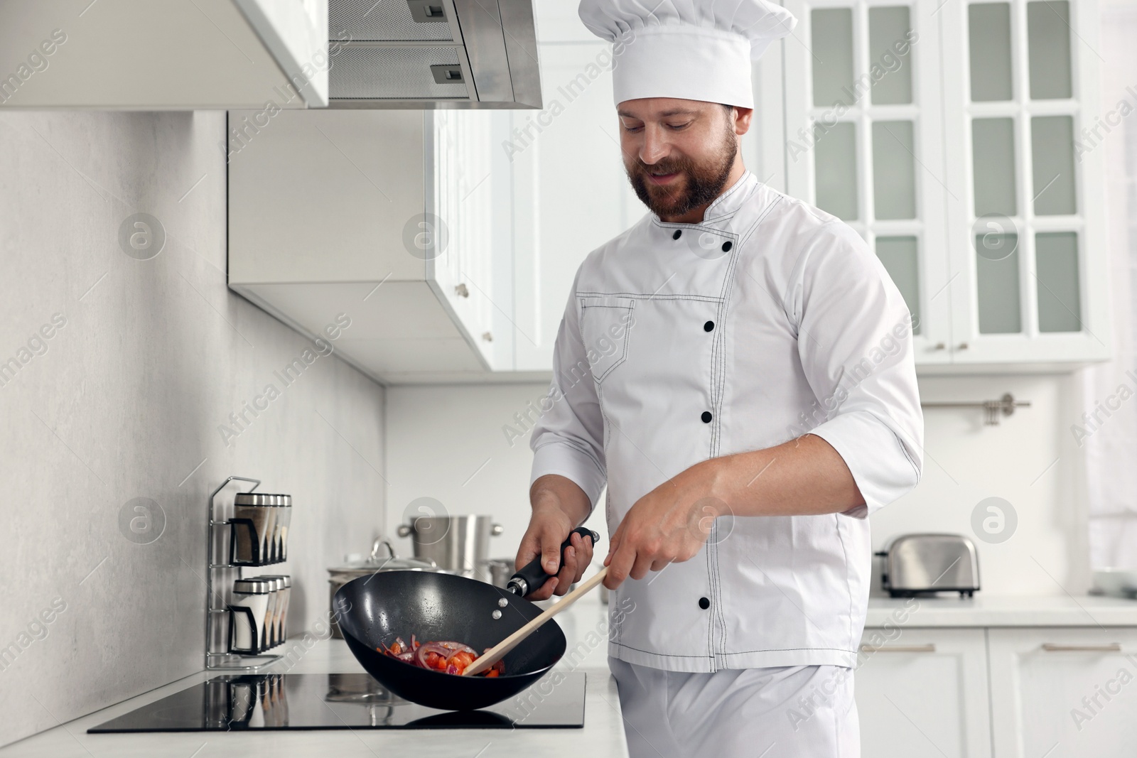 Photo of Professional chef cooking delicious food on stove in kitchen