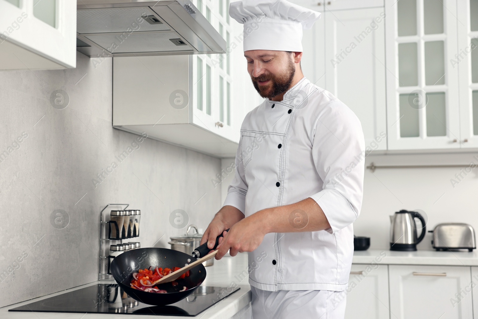 Photo of Professional chef cooking delicious food on stove in kitchen