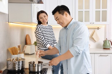 Photo of Happy lovely couple cooking together in kitchen