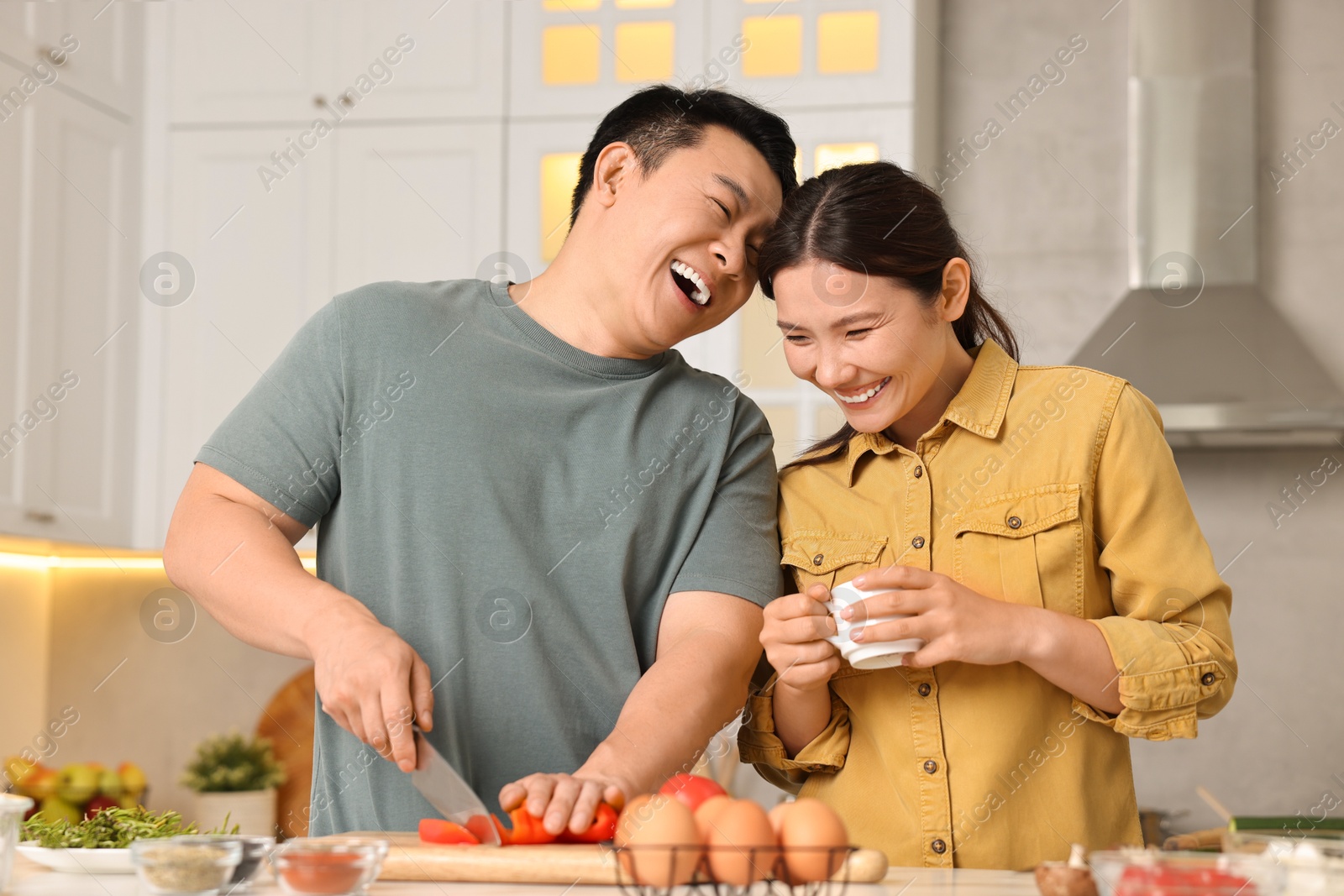 Photo of Happy lovely couple cooking together in kitchen