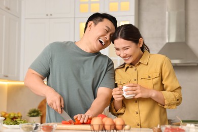 Happy lovely couple cooking together in kitchen