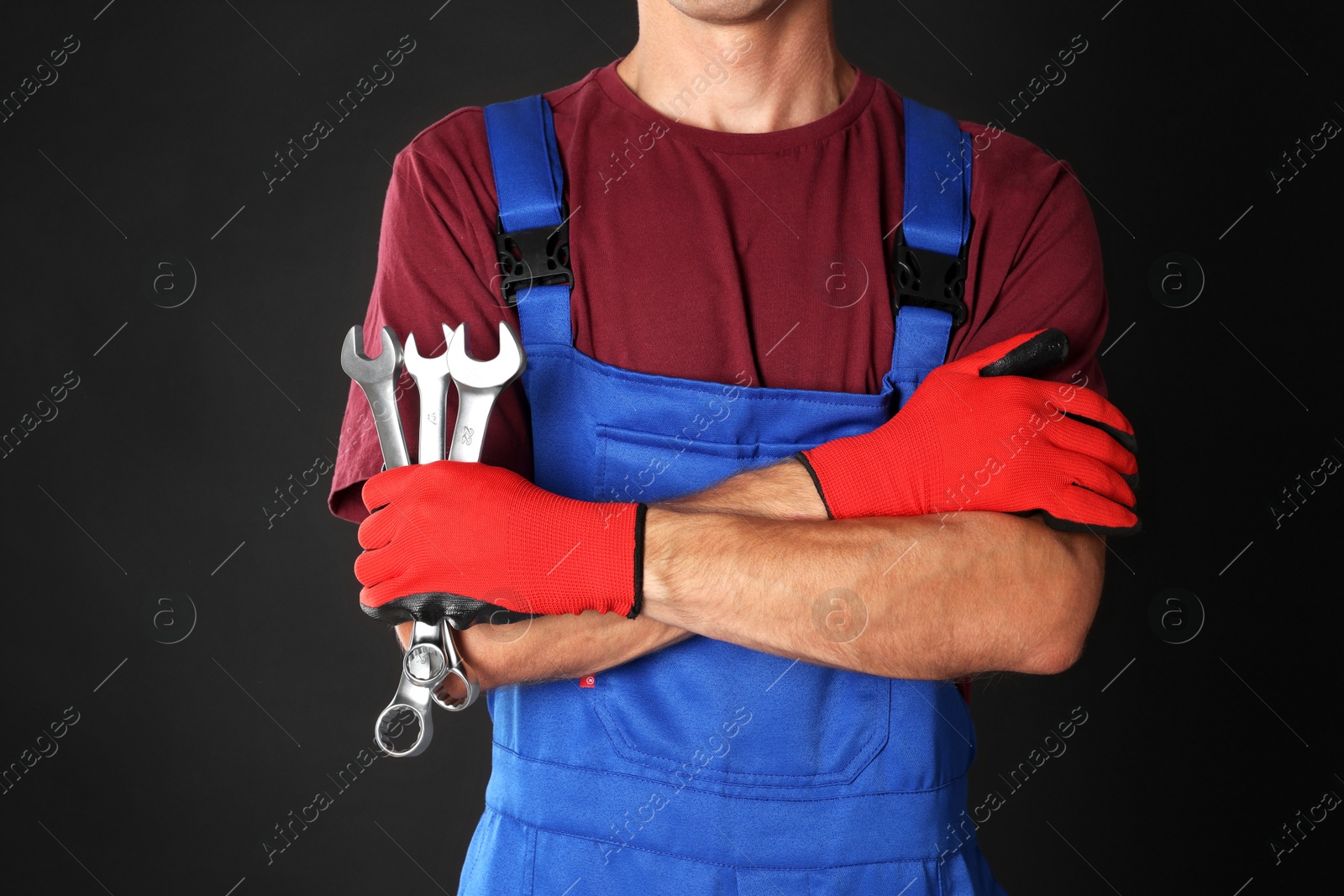 Photo of Auto mechanic with wrenches on black background, closeup