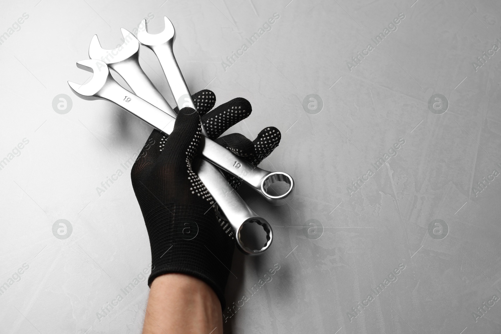 Photo of Auto mechanic with wrenches at light grey textured table, top view. Space for text