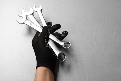 Photo of Auto mechanic with wrenches at light grey textured table, top view. Space for text