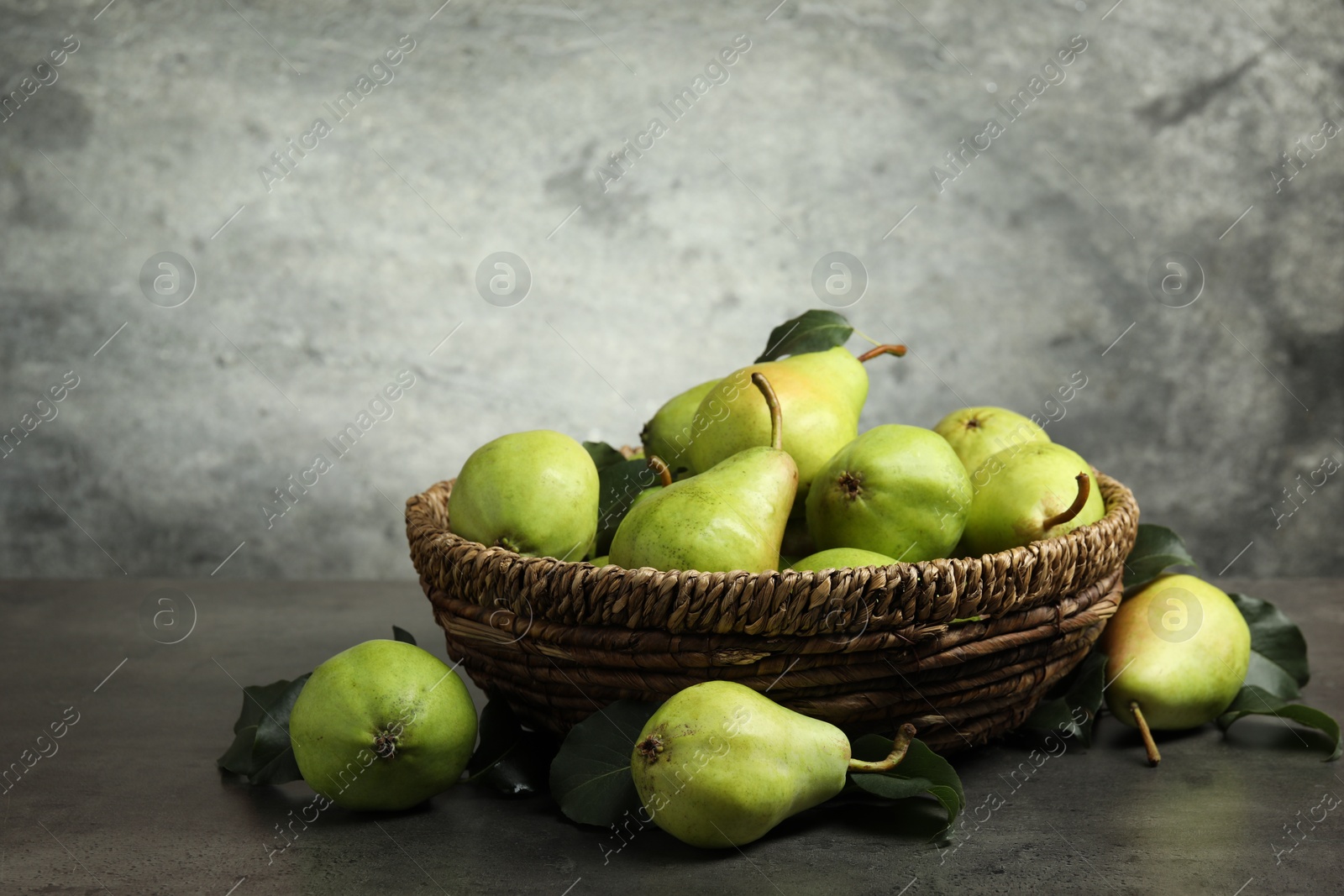 Photo of Many fresh ripe pears on grey table