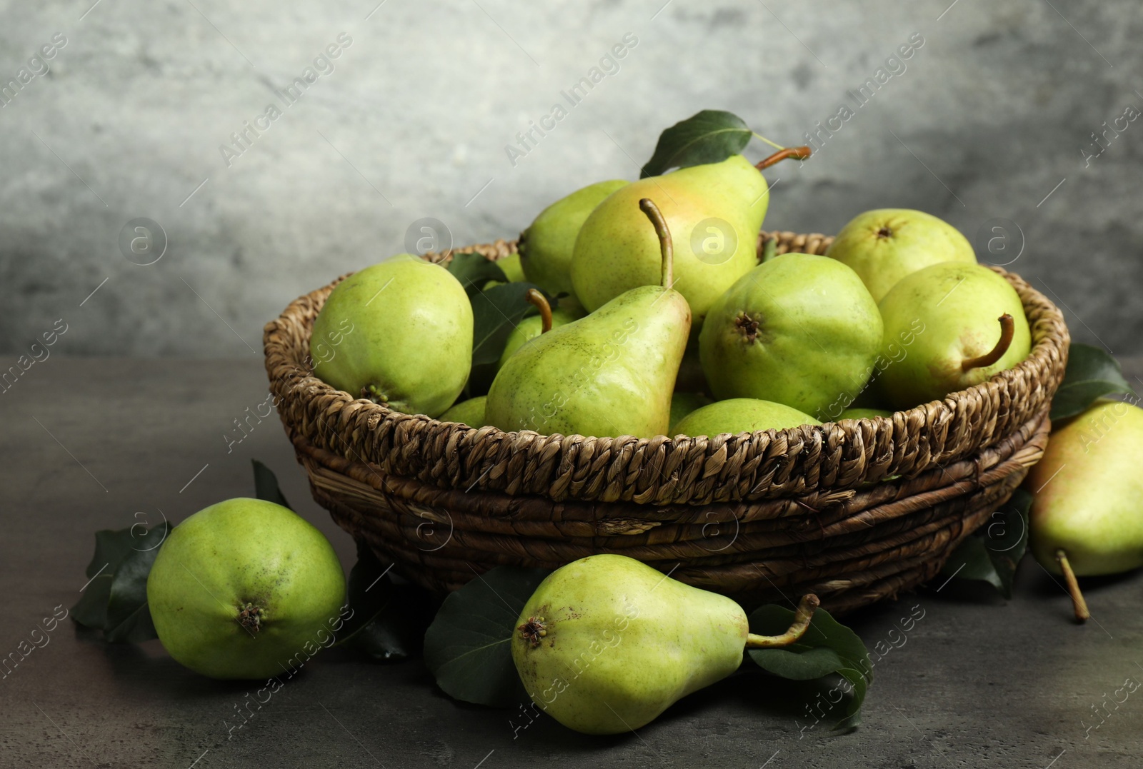 Photo of Many fresh ripe pears on grey table