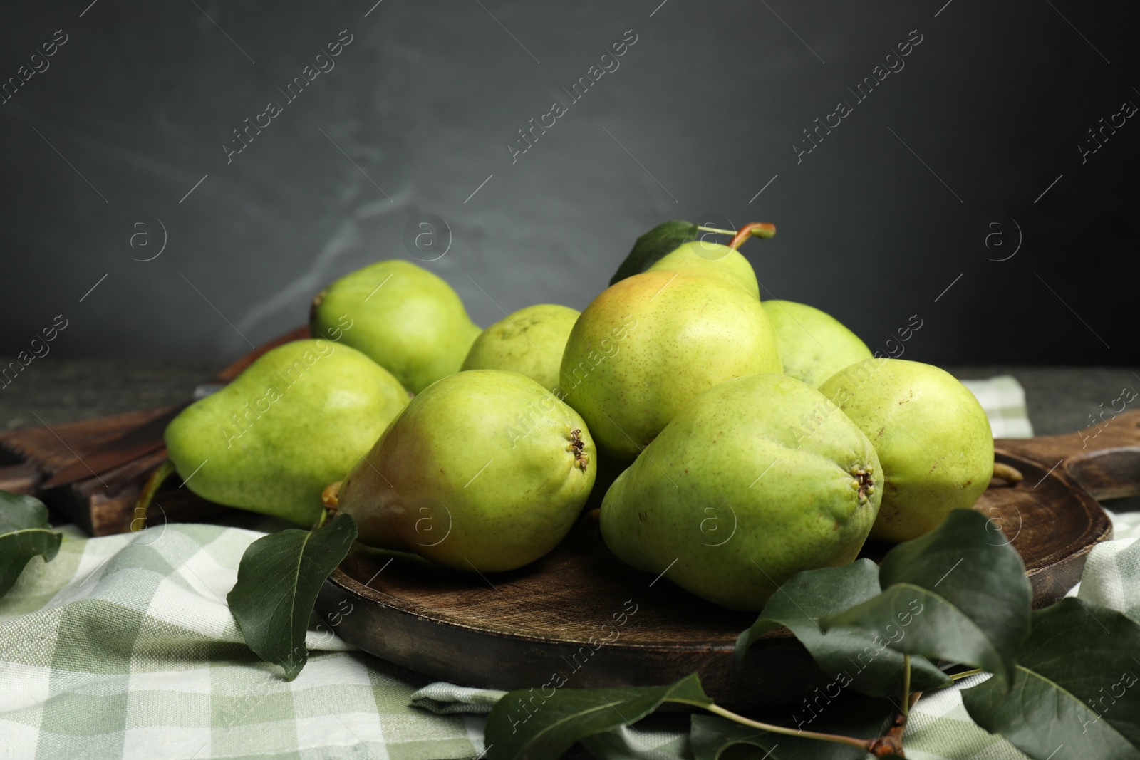 Photo of Many fresh ripe pears and green leaves on table