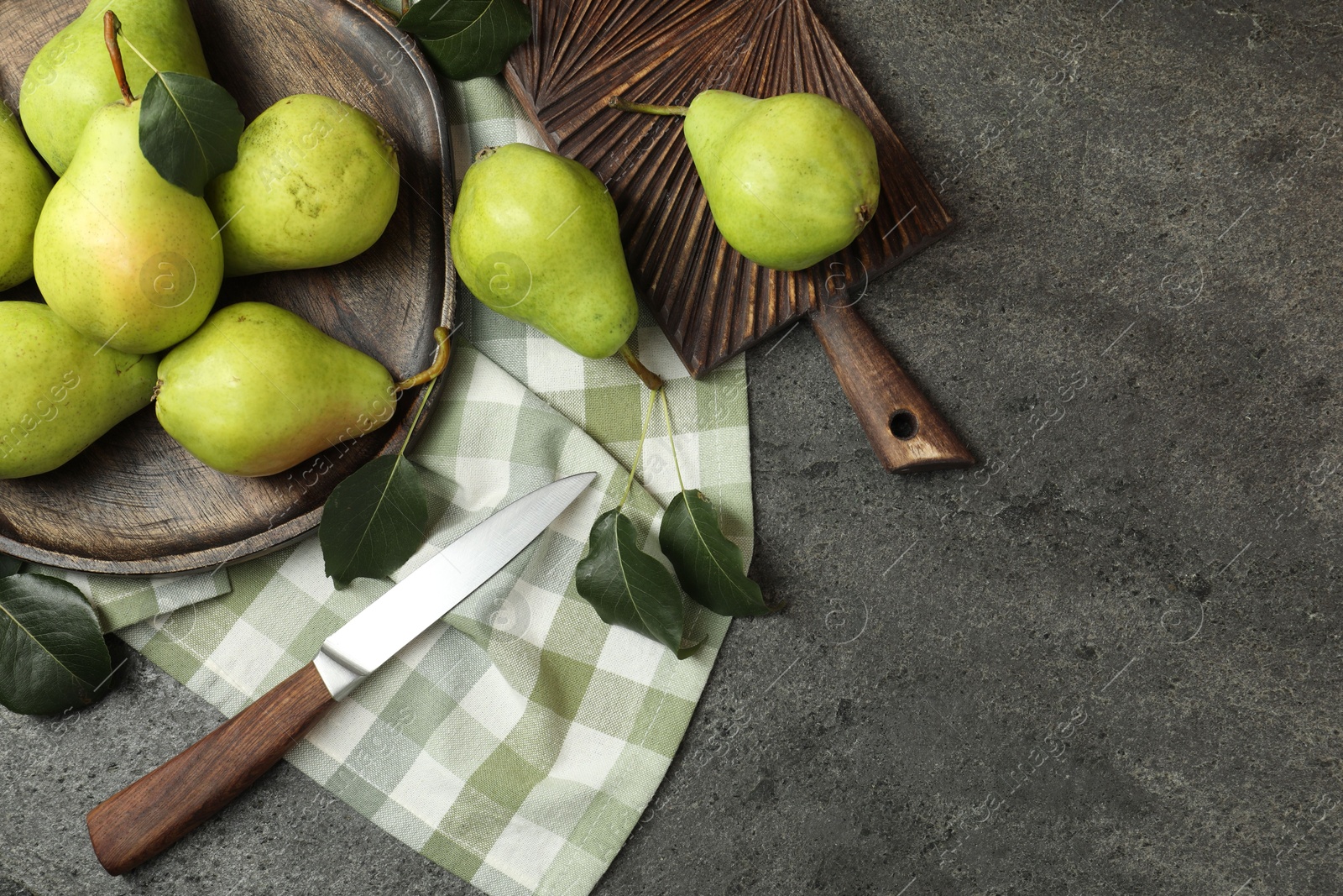 Photo of Many fresh ripe pears and knife on grey table, top view. Space for text