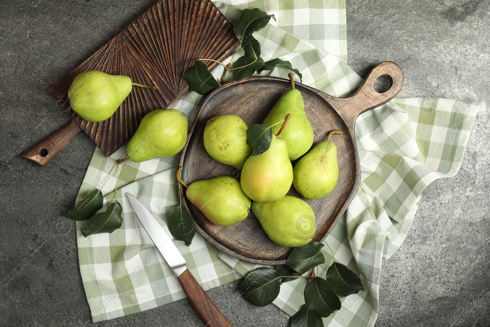 Photo of Many fresh ripe pears and knife on grey table, top view