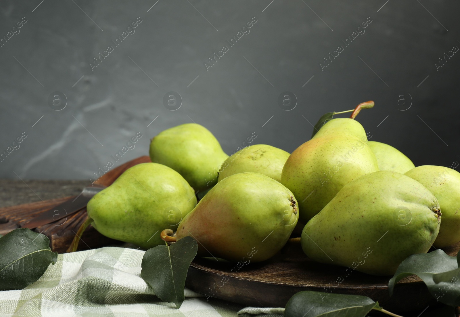 Photo of Many fresh ripe pears and green leaves on table