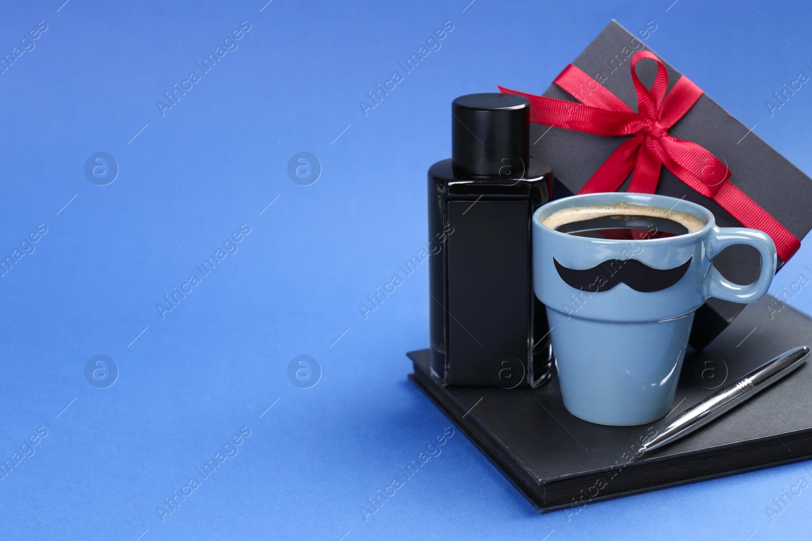 Photo of Happy Father's Day. Cup of coffee, notebook, pen, perfume and gift box on blue background. Space for text