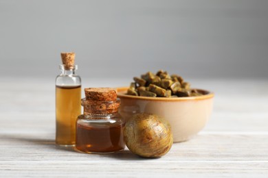 Photo of Natural honey tincture and propolis granules on white wooden table