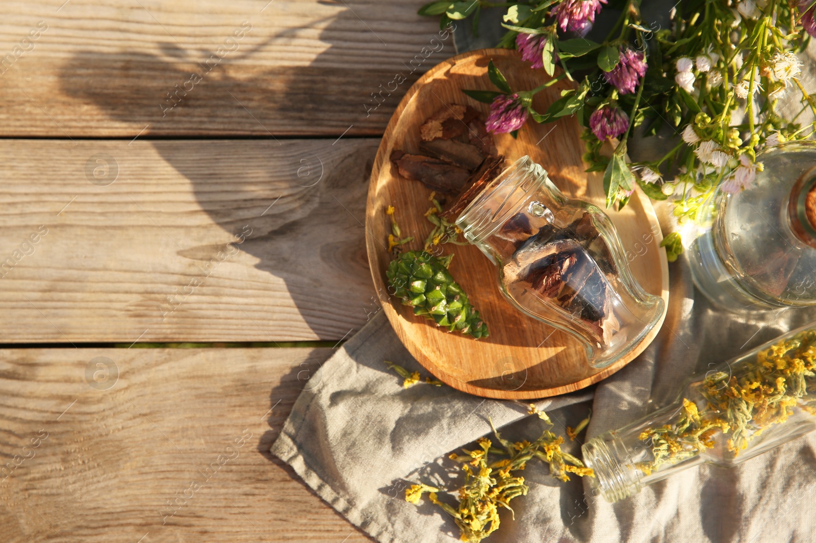 Photo of Tincture and different ingredients on wooden table, top view. Space for text