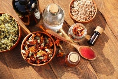 Photo of Different tinctures and ingredients on wooden table, flat lay