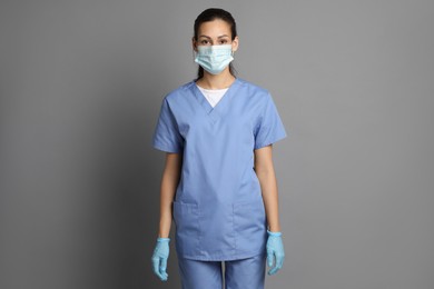 Portrait of nurse in medical mask and gloves on grey background