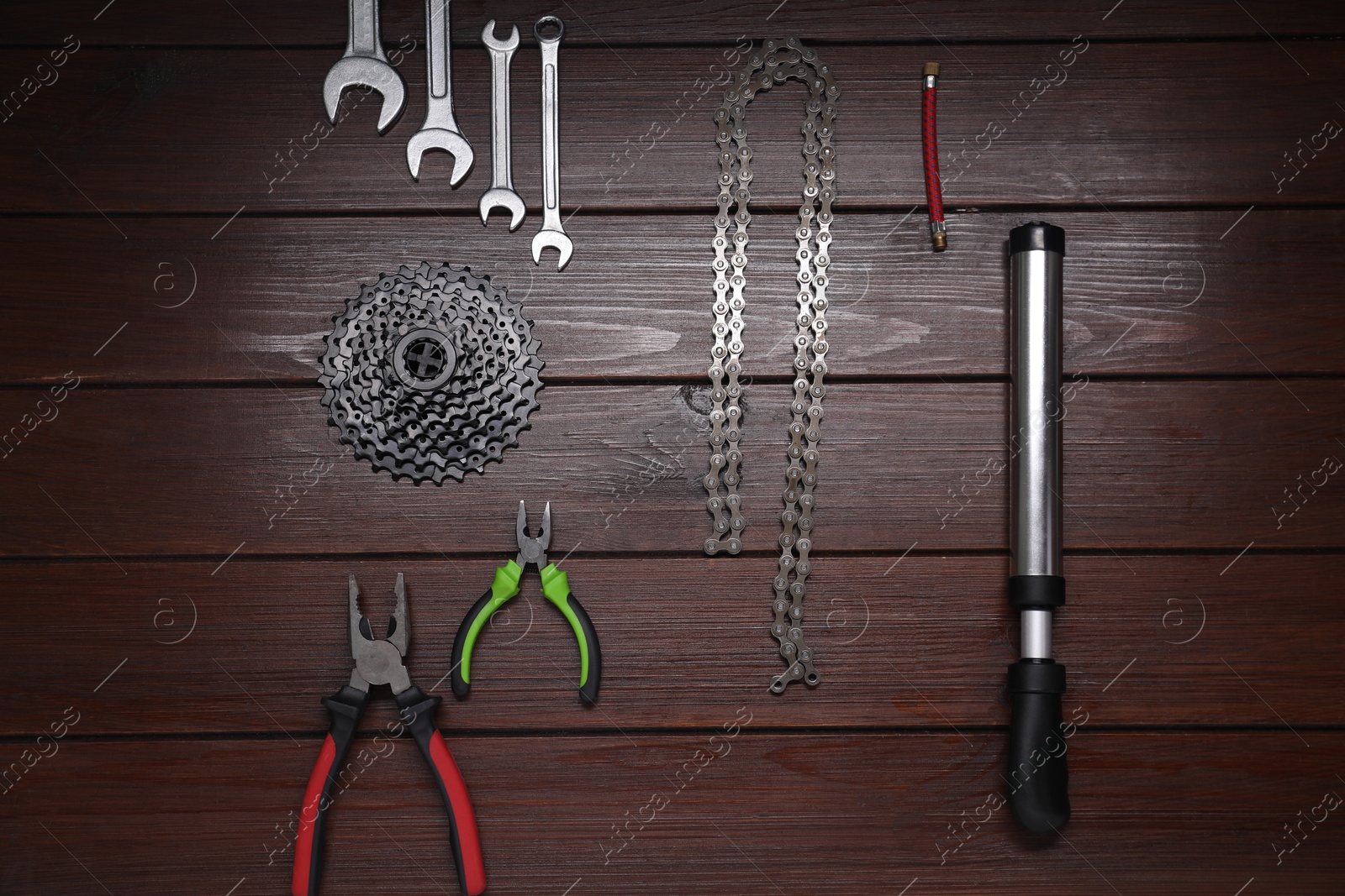 Photo of Flat lay composition with different bicycle components and tools on wooden background