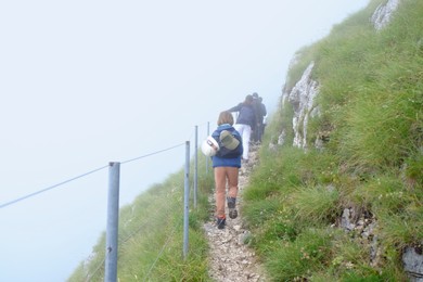 Photo of Group of tourists hiking in foggy mountains