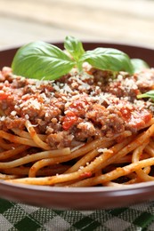 Photo of Delicious pasta bolognese with basil on table, closeup