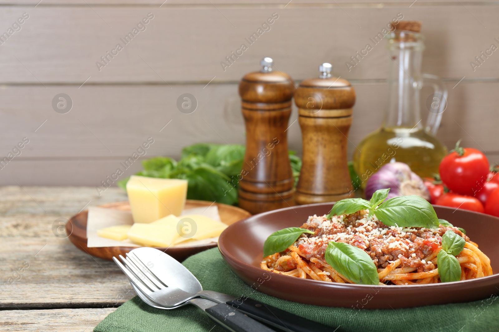 Photo of Delicious pasta bolognese with basil served on wooden table, closeup