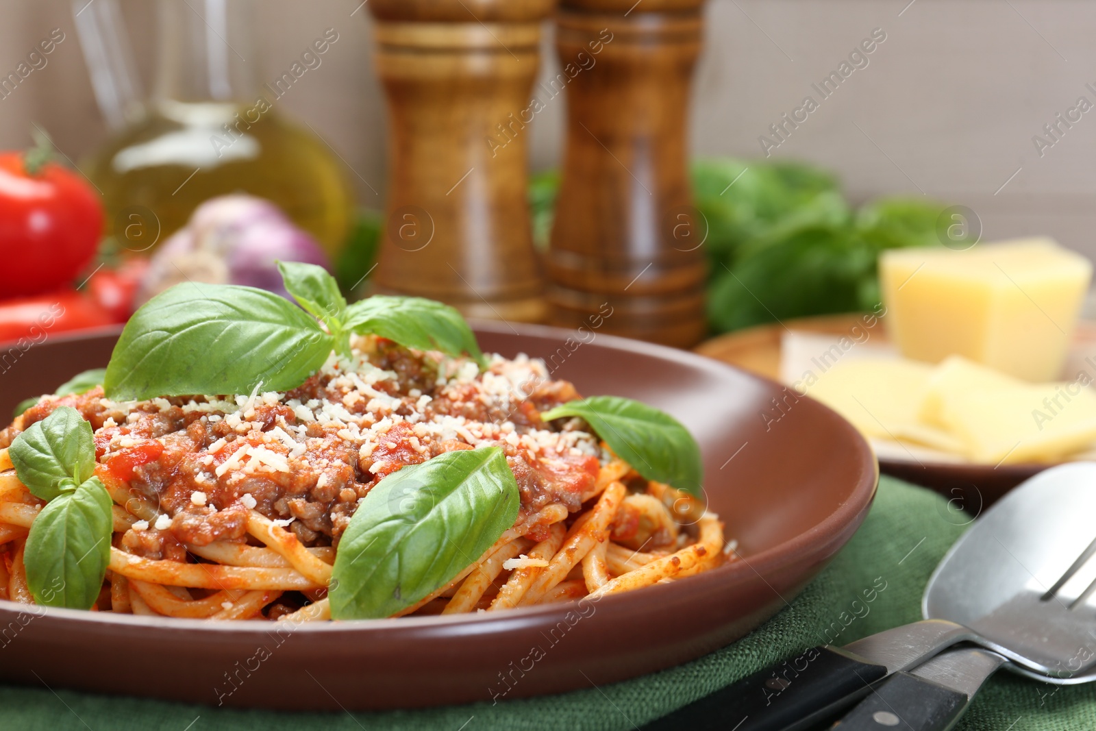 Photo of Delicious pasta bolognese with basil served on table, closeup