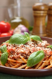 Photo of Delicious pasta bolognese with basil on table, closeup