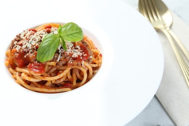 Photo of Delicious pasta bolognese with basil on table, closeup