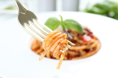 Photo of Eating delicious pasta bolognese at table, closeup