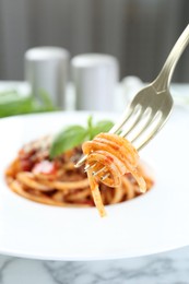 Photo of Eating delicious pasta bolognese at white marble table, closeup