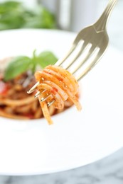 Photo of Eating delicious pasta bolognese at table, closeup