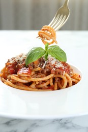 Photo of Eating delicious pasta bolognese at white marble table, closeup