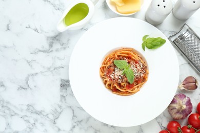 Photo of Delicious pasta bolognese with basil served on white marble table, top view. Space for text