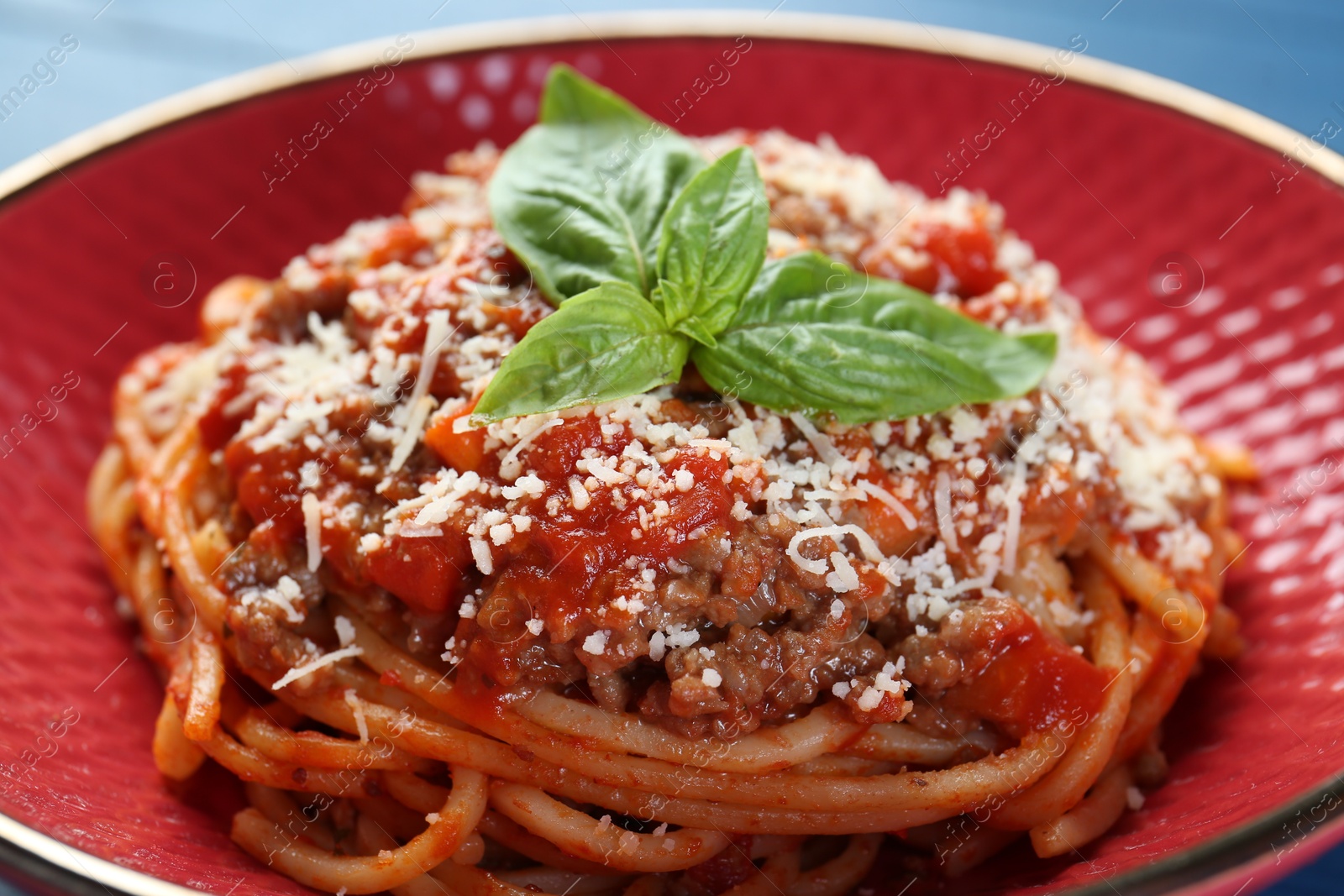 Photo of Delicious pasta bolognese with basil on table, closeup